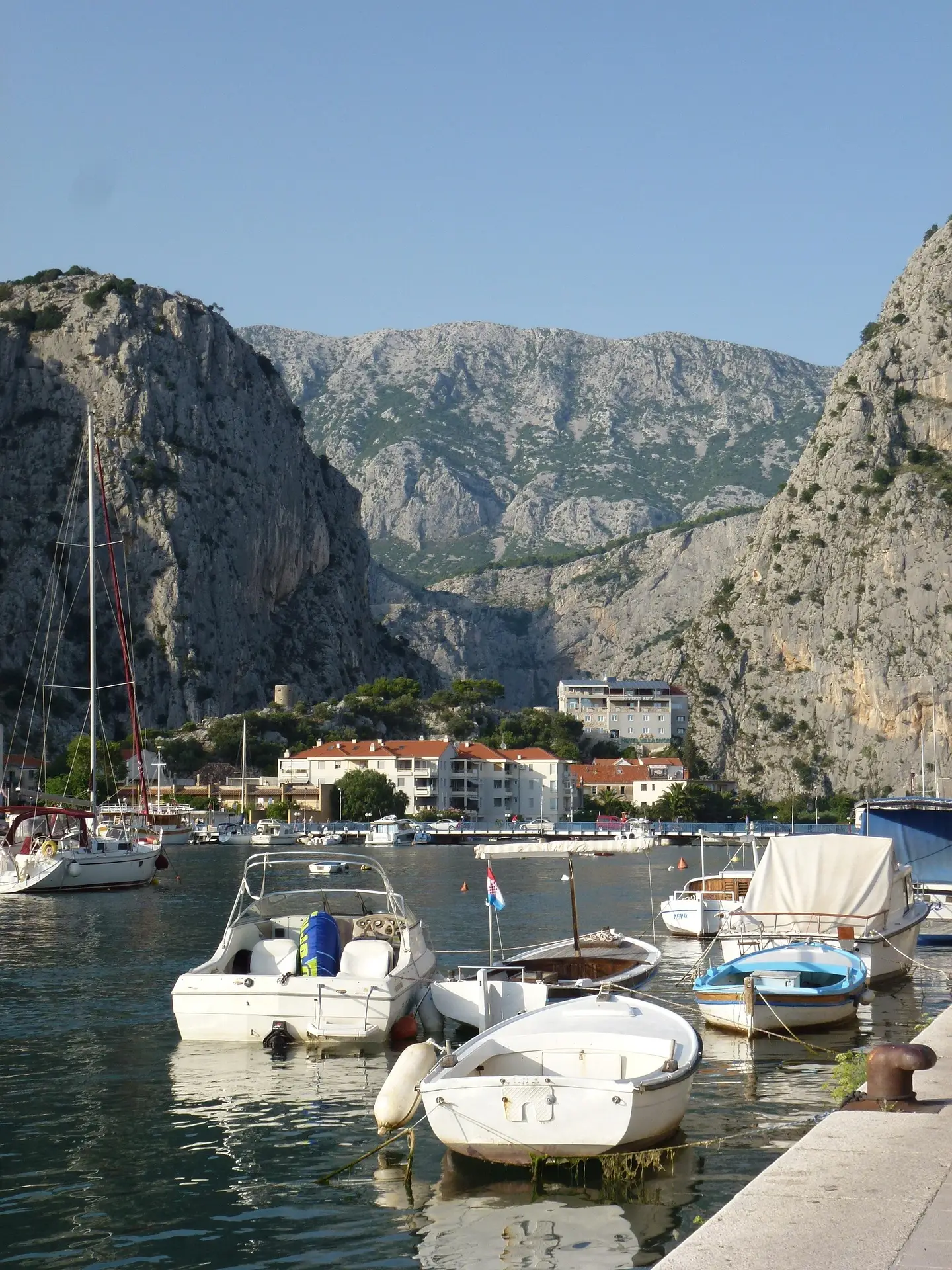 small harbor with boats and mountain behind