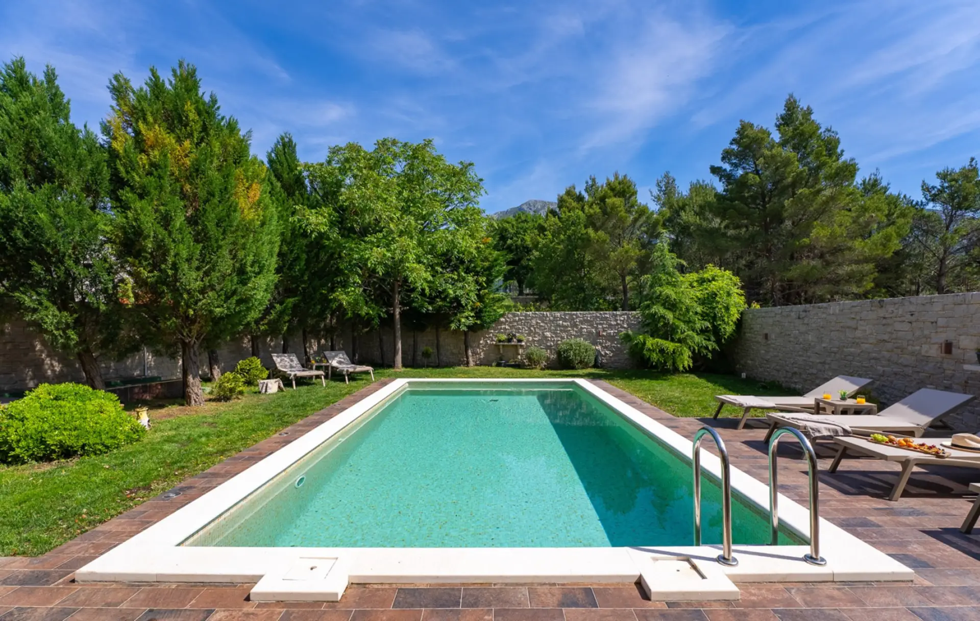 outdoor pool surrounded by green trees