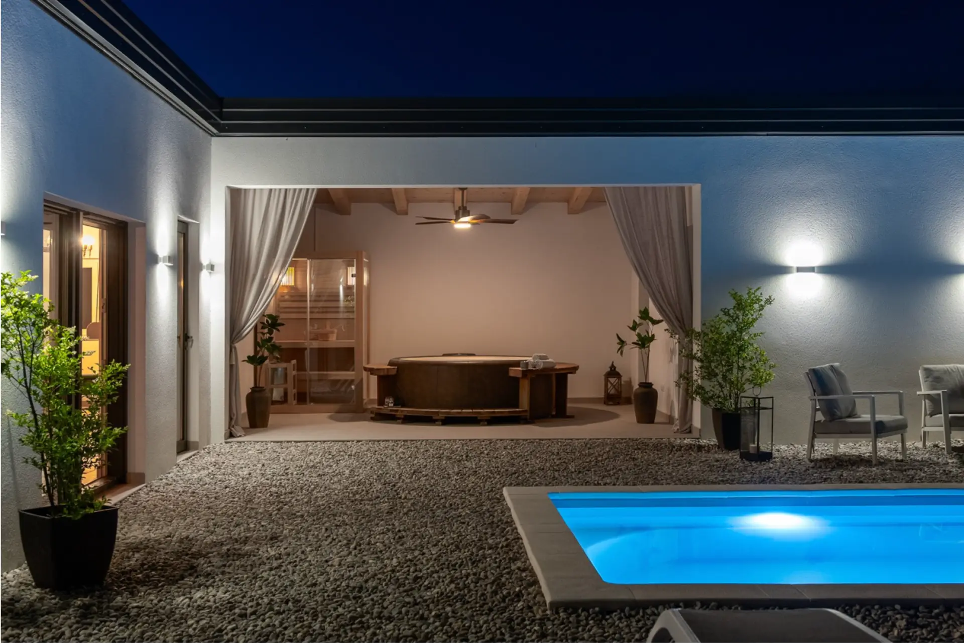 An outdoor whirpool and a pool by night