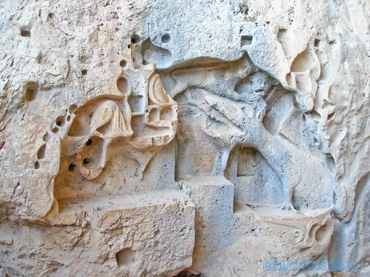 relief carving of a dragon on a cave