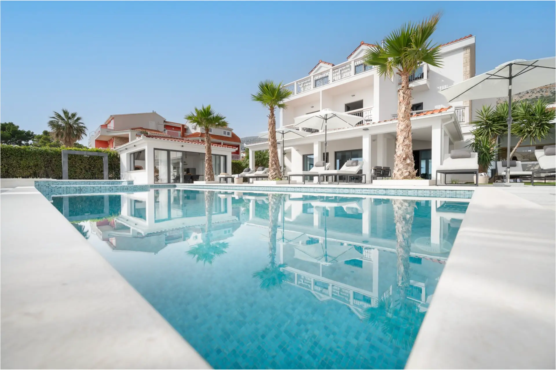 Pool in front of villa with palm trees
