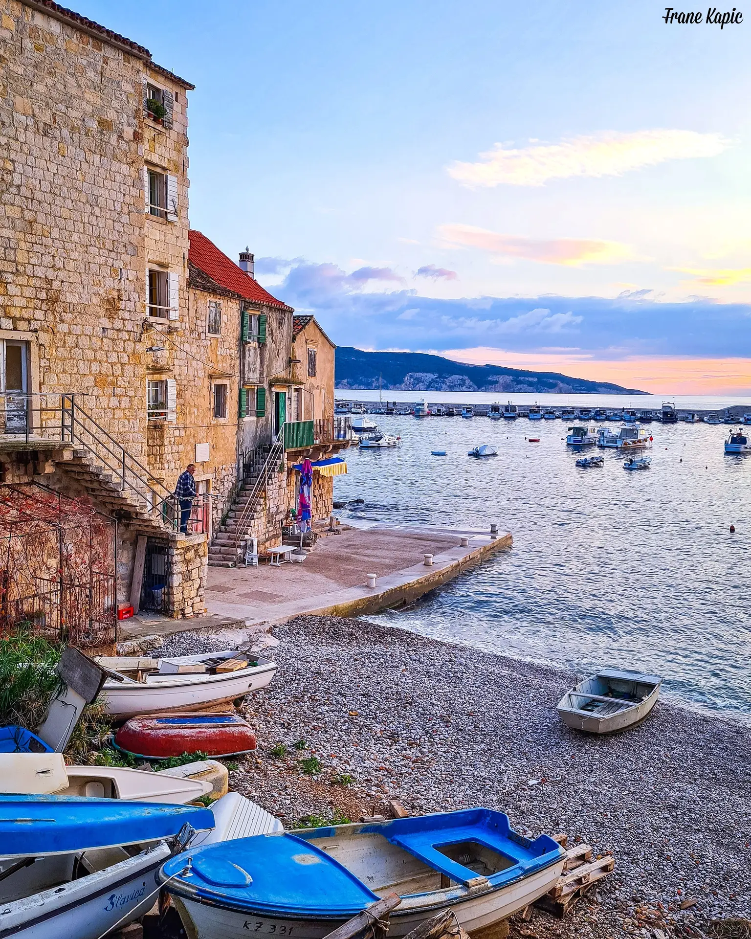 beachfront stone hosue with fishing ships