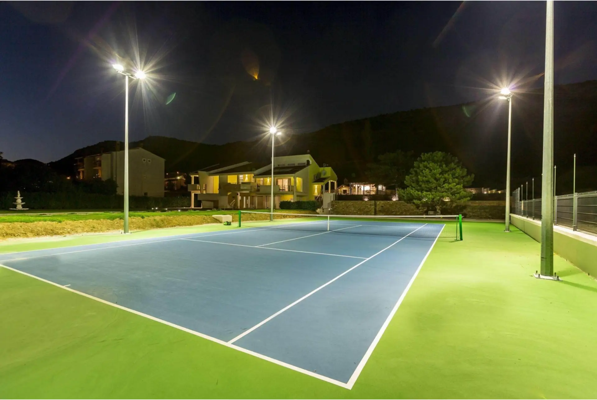 Blauer Tennisplatz bei Nacht