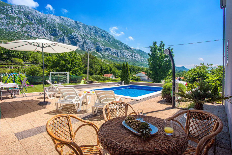 Pool with mountain view and fenced playground for children