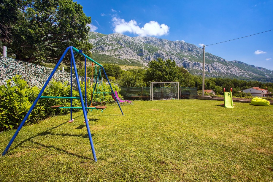 Kid's playground with swing and slide and football field
