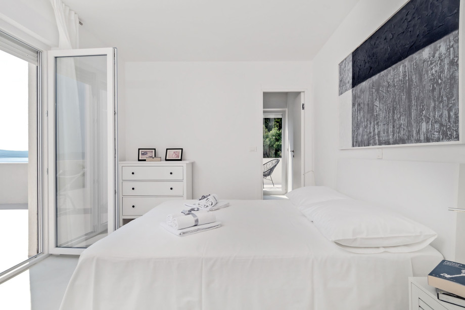 Bedroom on the 2nd floor with a double bed, bathroom, and exit to balcony