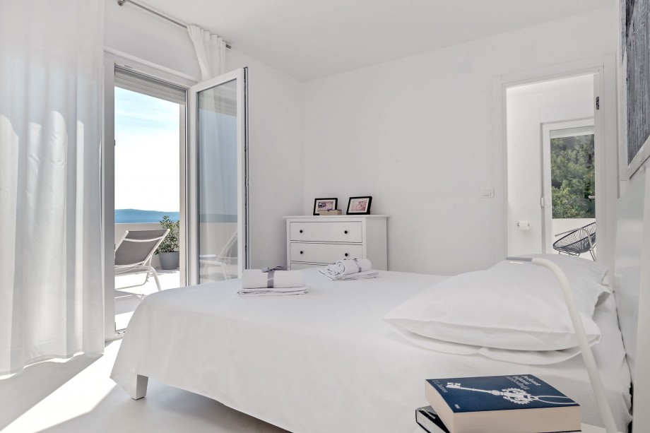 Bedroom on the 2nd floor with a double bed, bathroom, and exit to balcony