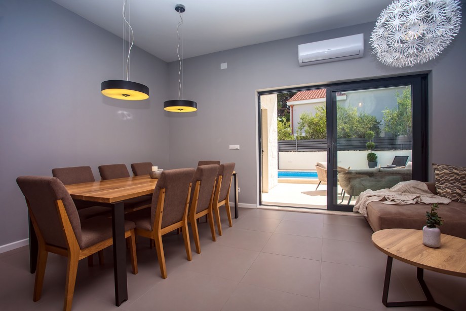 dining area with 8 chairs, next to the living area with exit to the terrace