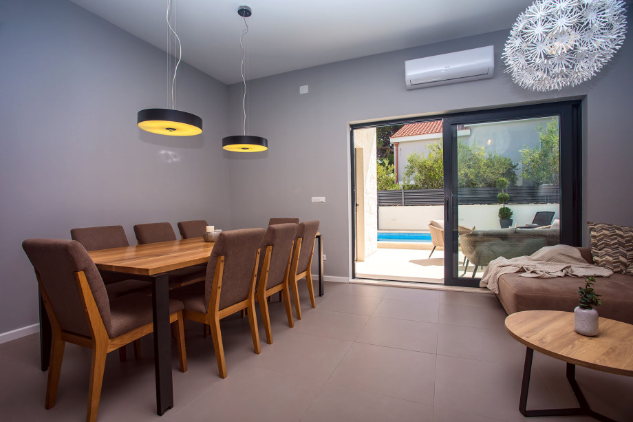 dining area with 8 chairs, next to the living area with exit to the terrace