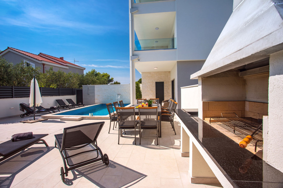 The pool area in front of the living area with dinning-and barbecue area