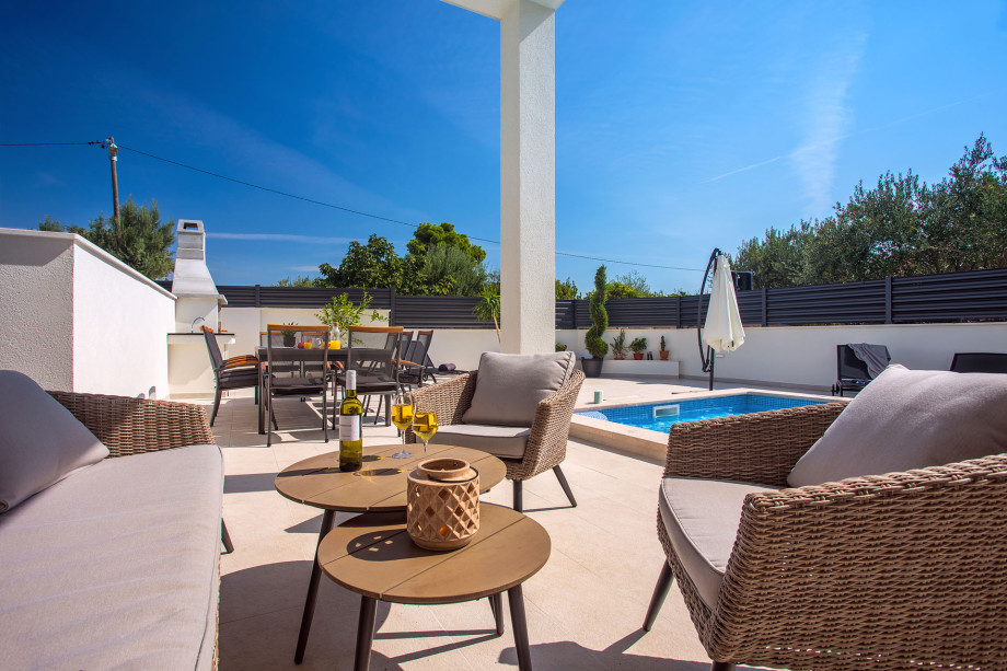 The pool area in front of the living area with dinning-and barbecue area