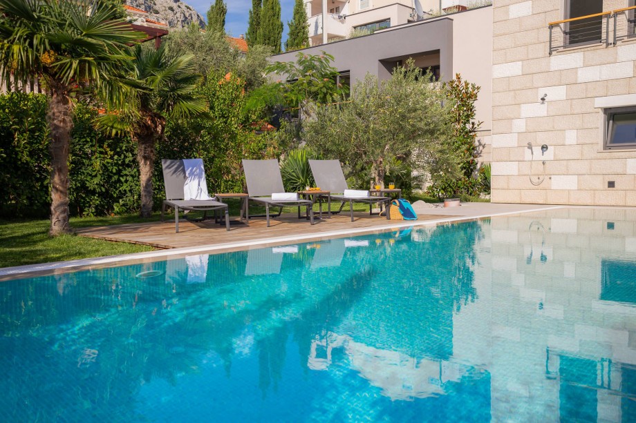 Enjoy the views from the pool area to Mediterranean garden and sandy beach on another side