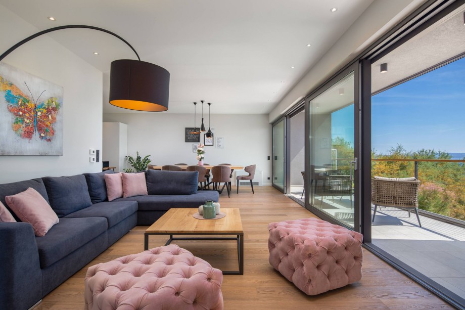 Luxuriously furnished living and dining area with glass wall on sea side, first floor