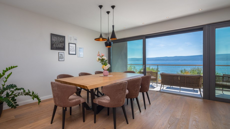 Luxuriously furnished living and dining area with glass wall on sea side, first floor