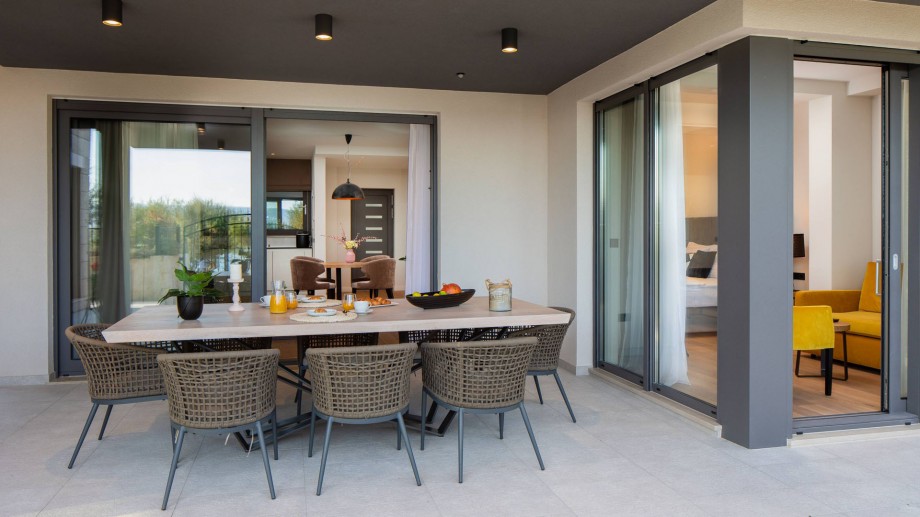 Covered outdoor dining area at ground floor next to the indoor pool area