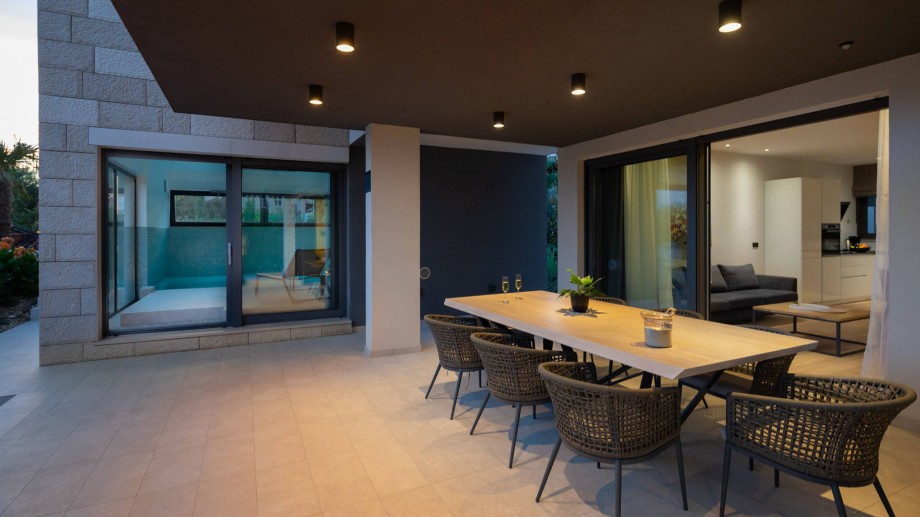 Covered outdoor dining area at ground floor next to the indoor pool area