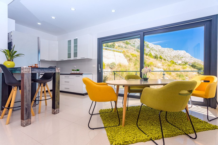 A glass wall offers a direct approach to the outdoor dining area