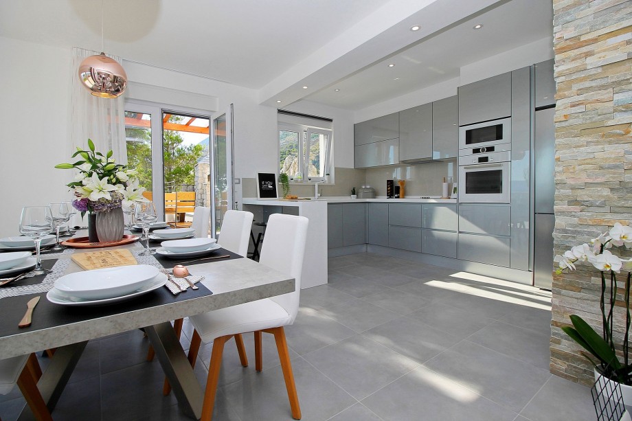 Fully equipped and modern kitchen connected with outdoor dining area and grill