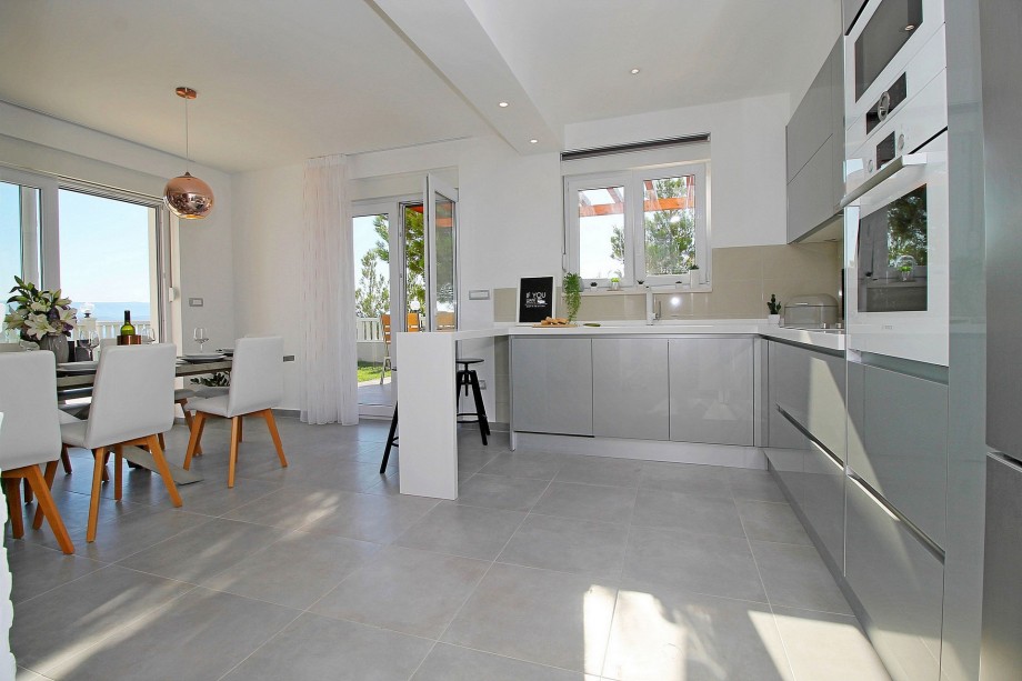 Fully equipped and modern kitchen connected with outdoor dining area and grill