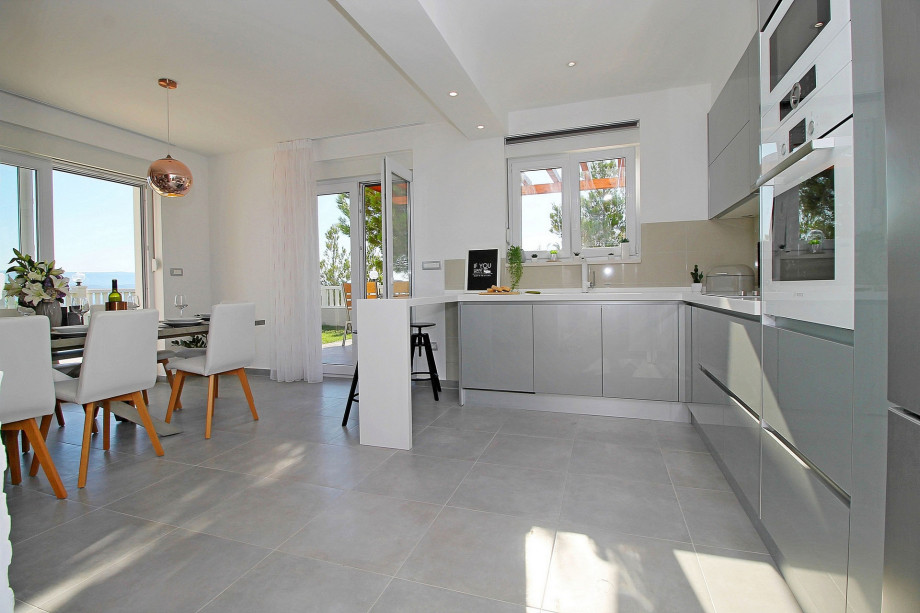 Fully equipped and modern kitchen connected with outdoor dining area and grill