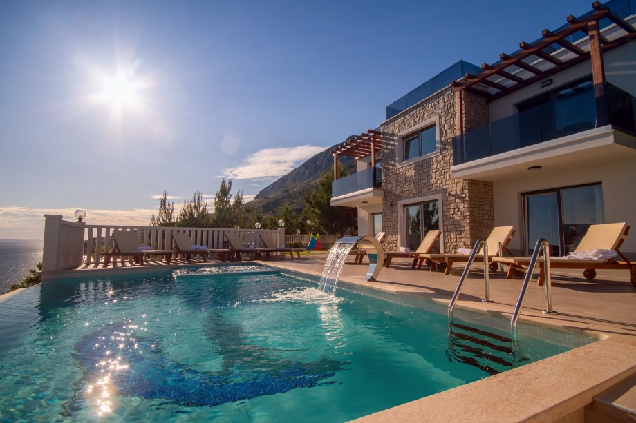 Heated pool with whirlpool and 8 lounge chairs on the sun deck area