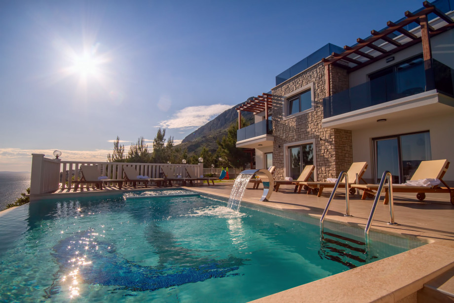 Heated pool with whirlpool and 8 lounge chairs on the sun deck area