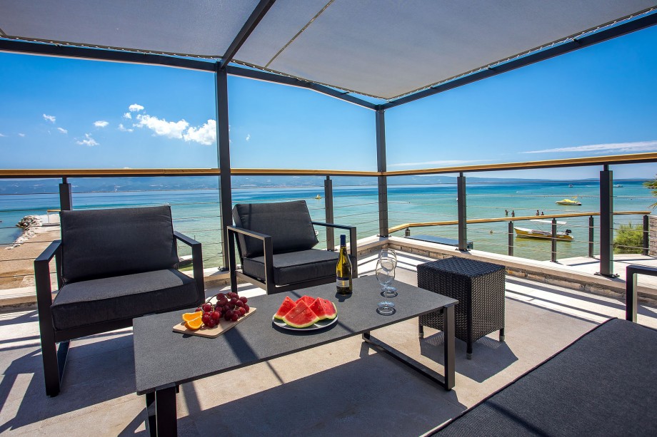 Outdoor sitting area in shadow with open sea view