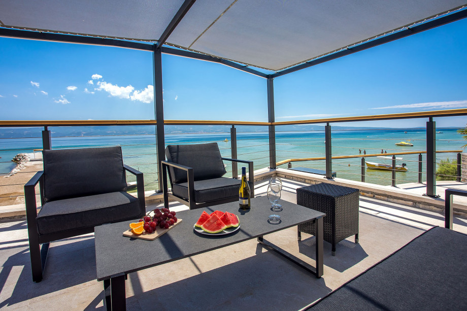 Outdoor sitting area in shadow with open sea view
