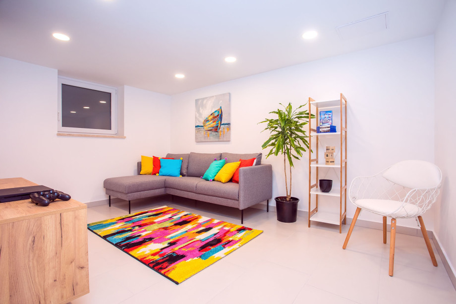 Playroom on the lower ground floor with a TV, a sofa and a Play Station 4