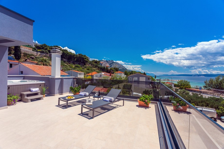 Terrace on the second floor with a jacuzzi, lounge chairs and open sea view