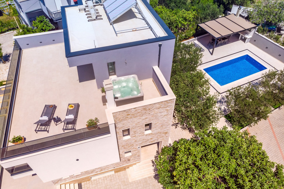 Terrace on the second floor with a jacuzzi, lounge chairs and open sea view