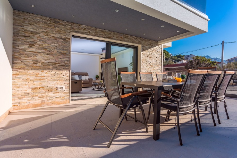 In front of the living room, it is an outdoor dining area for 10 people