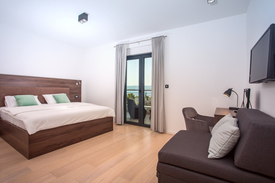 sofa bed, TV and a terrace with sea and pool views