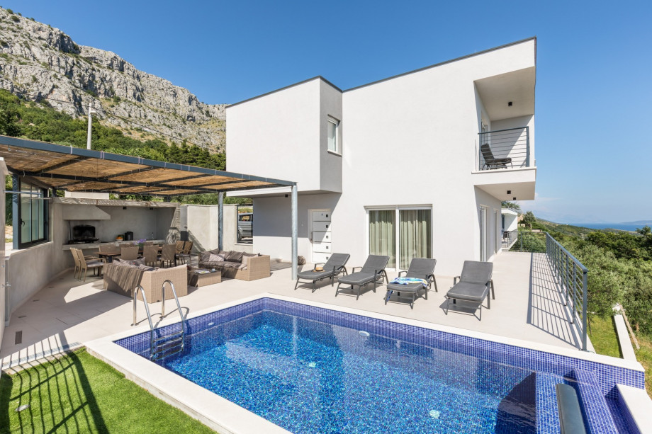 Private heated pool with infinity edge and comfortable lounge chairs