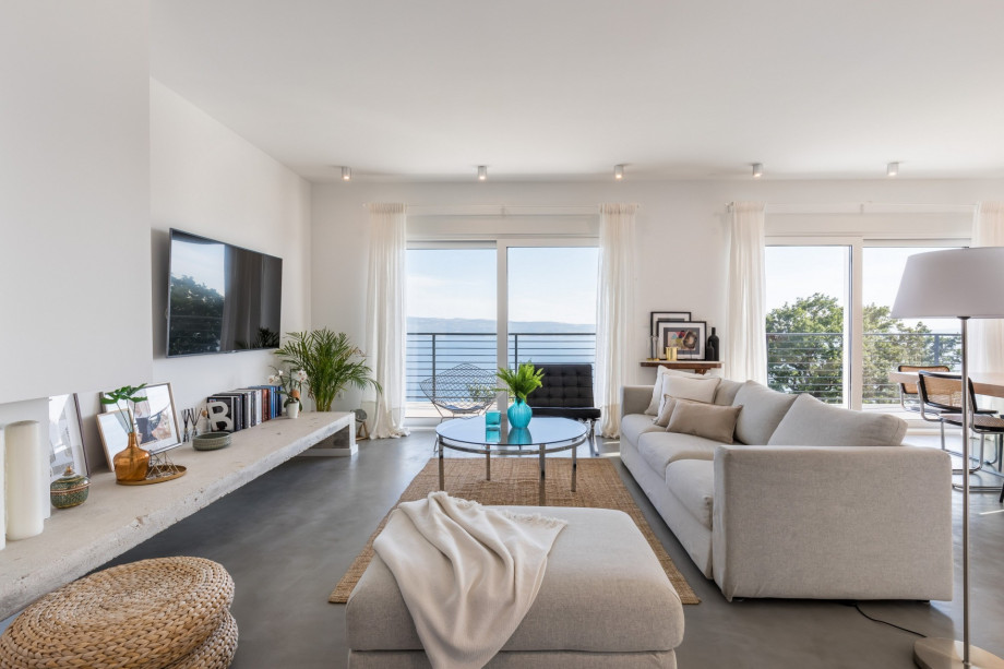 Spacious and modern living area connected with dining area and exit to the pool