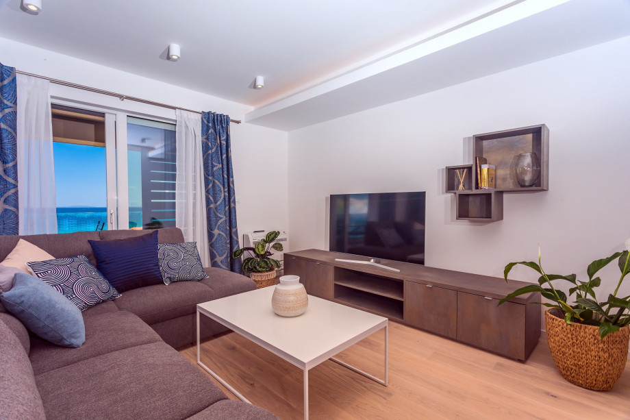 The spacious living area on the first floor with TV, AC, and exit to terrace