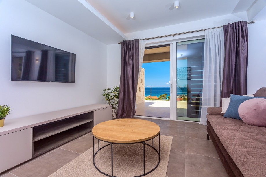 Spacious living area on the ground floor with TV, AC, and exit to the terrace.