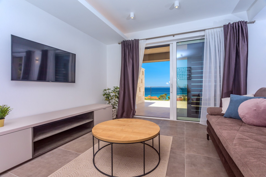 Spacious living area on the ground floor with TV, AC, and exit to the terrace.