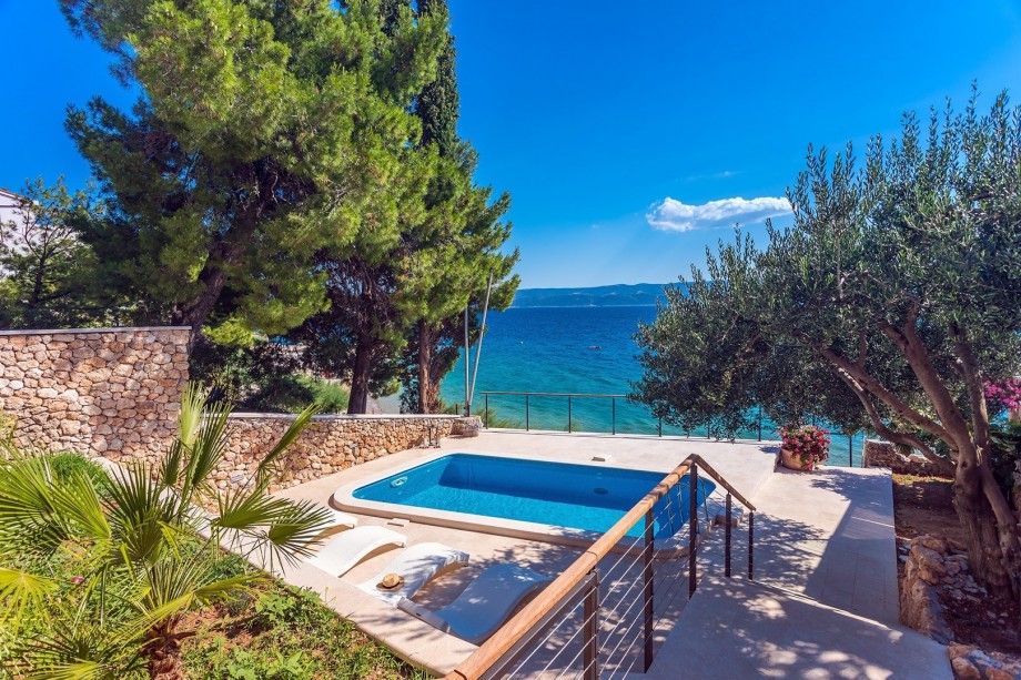 The outdoor area offers a private, heated swimming pool 6m x 3,5m (21sqm) with a hydro massage, 4 sun deck chairs, and an outdoor shower