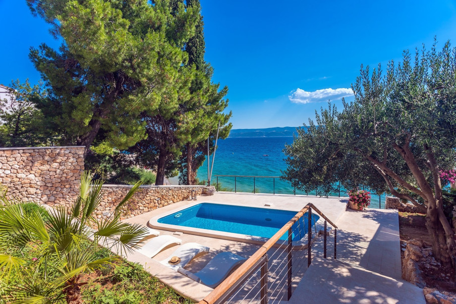 The outdoor area offers a private, heated swimming pool 6m x 3,5m (21sqm) with a hydro massage, 4 sun deck chairs, and an outdoor shower