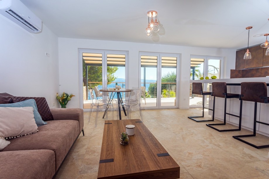 Living area and exit to terrace with two relaxing egg chairs and amazing sea and pool views