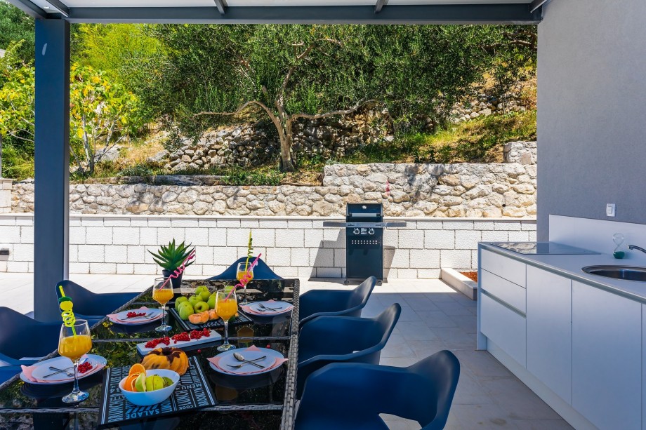 Barbecue is next to the summer kitchen