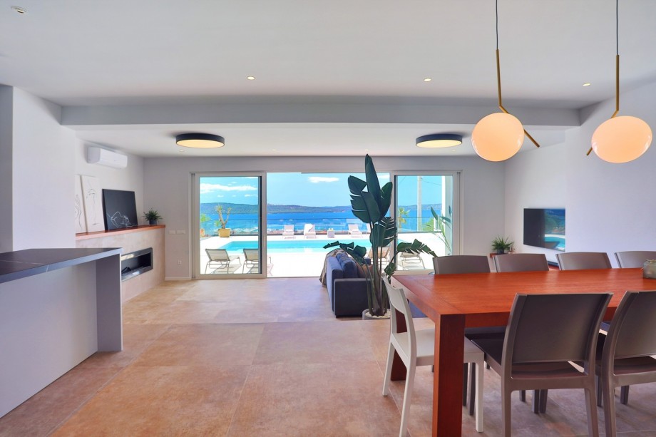 The living area has glass walls toward the pool and outdoor area.