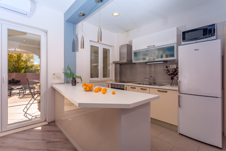 Fully equipped  kitchen and exit to pool area