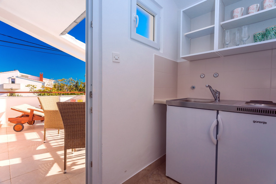Kitchenette in the bedroom No.5 with a balcony with a deck chair, sea and pool views