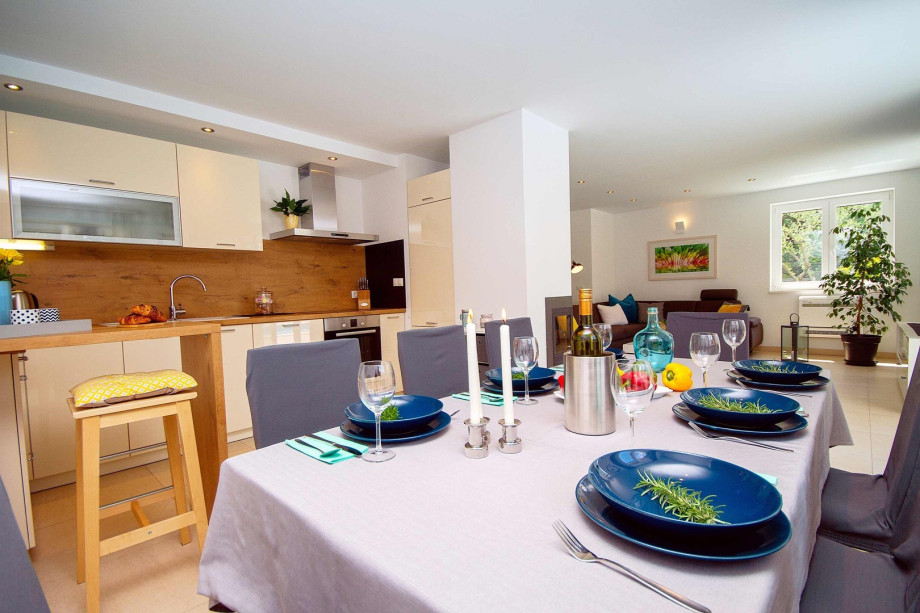 Fully equipped kitchen with dining and living room, and exit to pool area