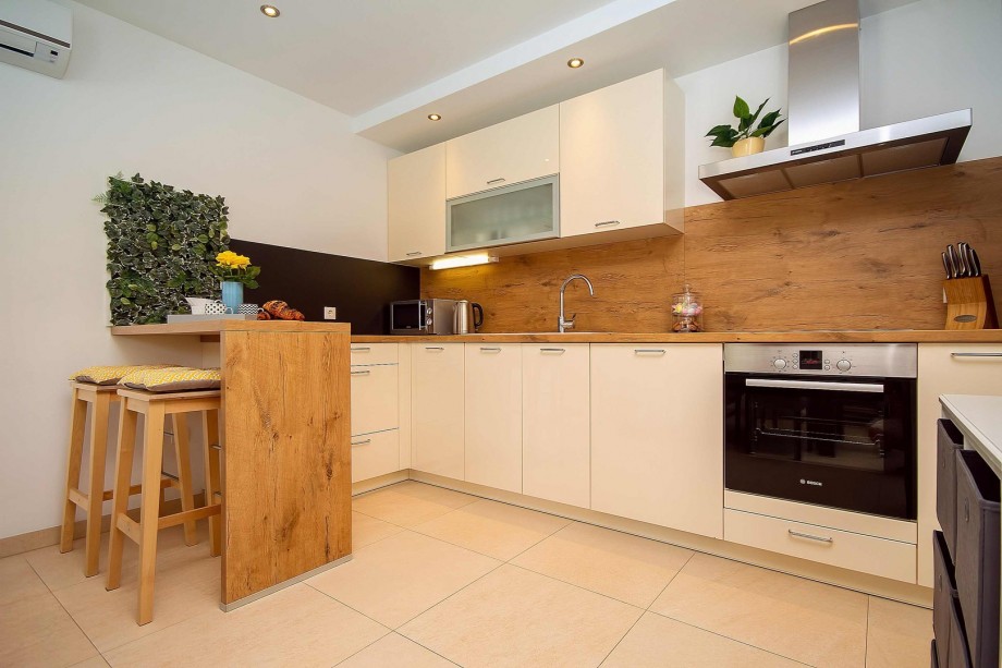 Fully equipped kitchen with dining and living room, and exit to pool area