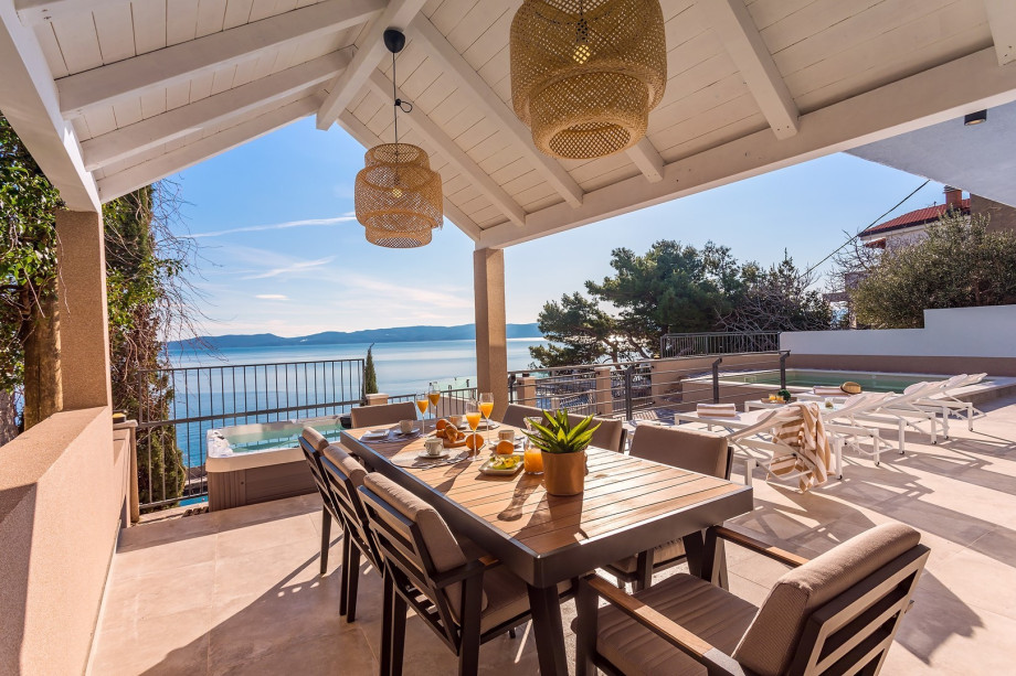 Covered dining room for 8 people with open sea views