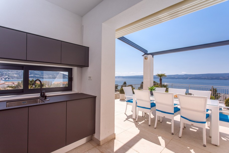 An outdoor dining area for 8, and a traditional barbecue next to it