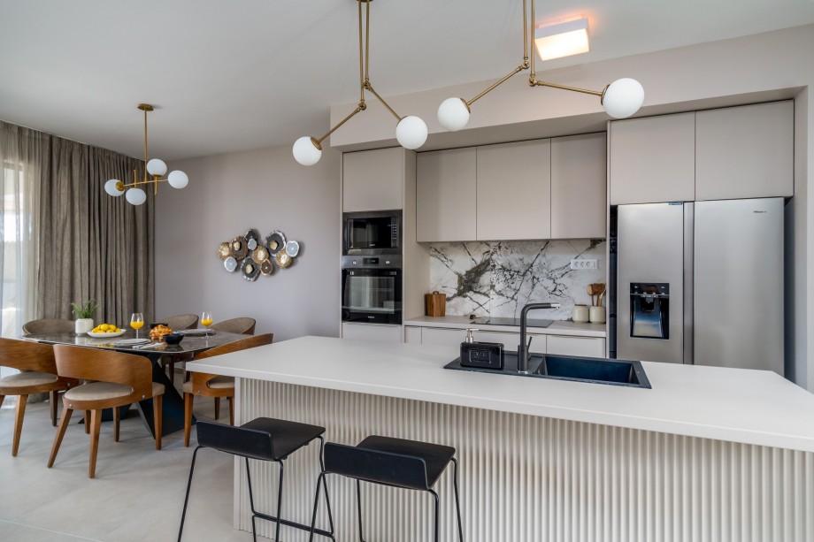 A fully equipped kitchen with a kitchen island and all of the required appliances